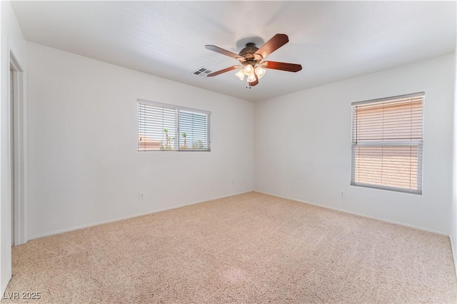 carpeted empty room with visible vents and a ceiling fan