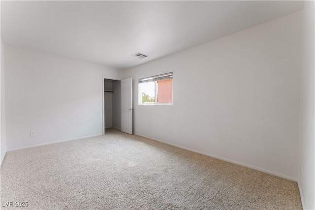 unfurnished bedroom featuring a closet, light carpet, and visible vents