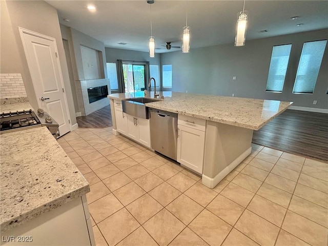 kitchen featuring dishwasher, open floor plan, a sink, and light tile patterned flooring
