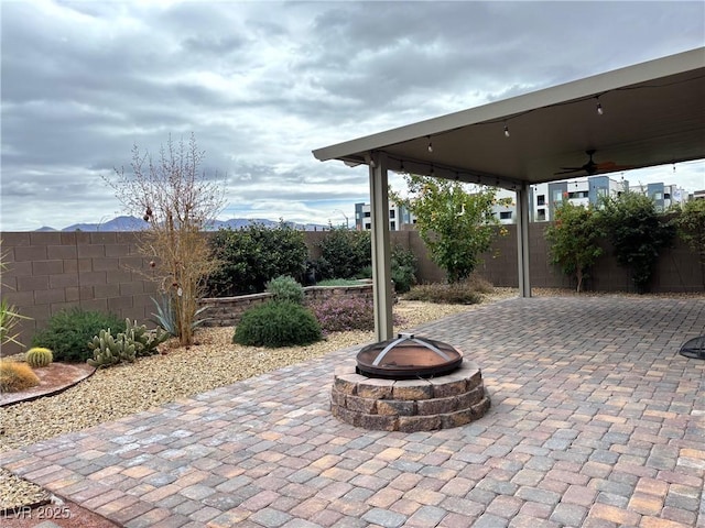 view of patio / terrace featuring an outdoor fire pit, a fenced backyard, and ceiling fan