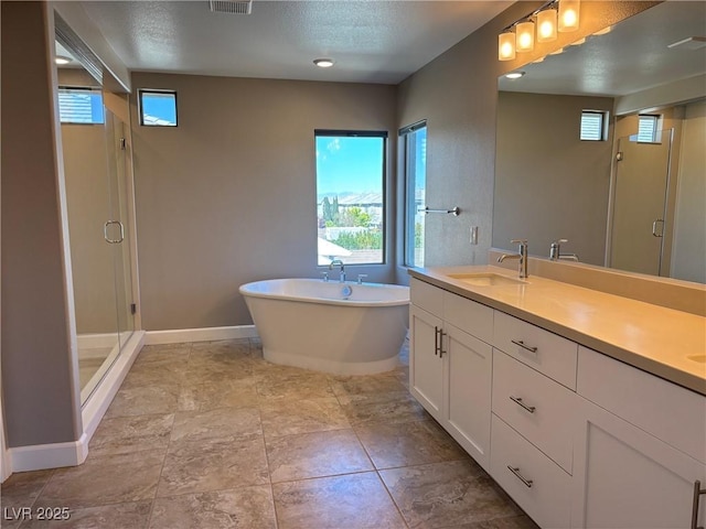 full bathroom with a stall shower, a freestanding tub, a sink, baseboards, and double vanity