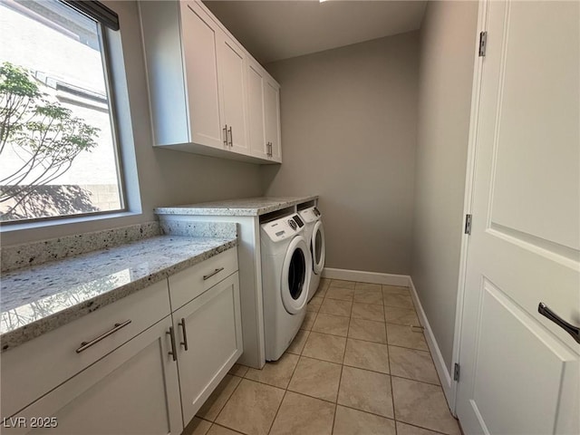 laundry area with washing machine and clothes dryer, cabinet space, baseboards, and light tile patterned floors