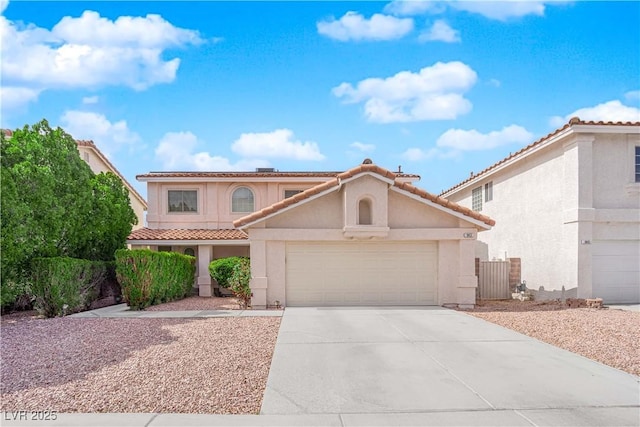 mediterranean / spanish home with a garage, driveway, a tiled roof, and stucco siding