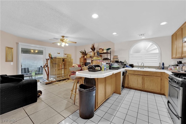 kitchen with black dishwasher, tile countertops, a peninsula, and gas range