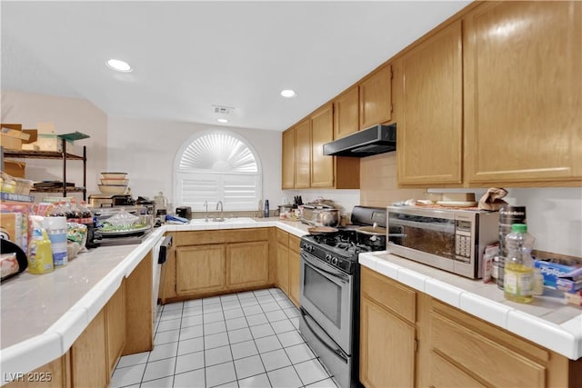 kitchen featuring tile countertops, light tile patterned flooring, under cabinet range hood, stainless steel appliances, and visible vents