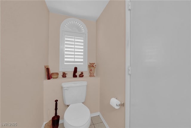 bathroom with tile patterned flooring, toilet, and baseboards