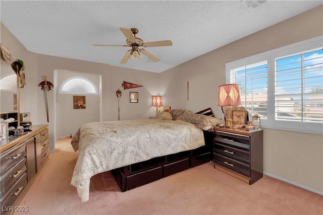 bedroom featuring light carpet, a ceiling fan, baseboards, and a textured ceiling