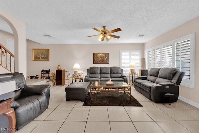 living area with visible vents, light tile patterned flooring, ceiling fan, and a textured ceiling