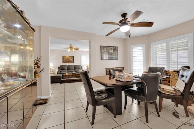 dining space with ceiling fan, light tile patterned flooring, and baseboards