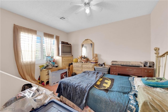 carpeted bedroom featuring a ceiling fan, visible vents, and a textured ceiling