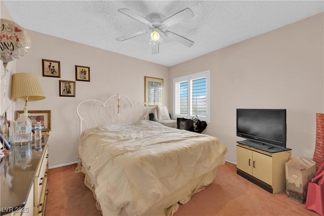 bedroom featuring light carpet, a ceiling fan, and a textured ceiling