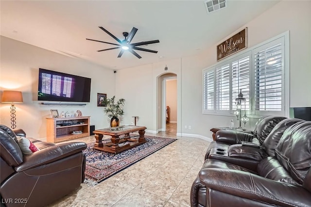 living room featuring arched walkways, visible vents, ceiling fan, and baseboards