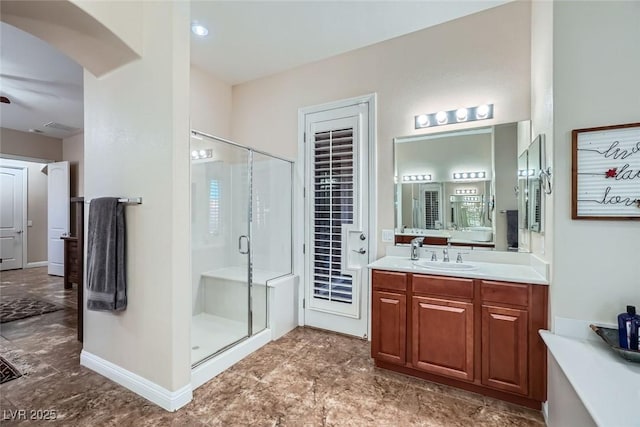 bathroom featuring a stall shower, baseboards, and vanity