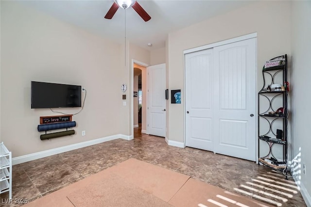 unfurnished bedroom featuring arched walkways, a closet, ceiling fan, and baseboards