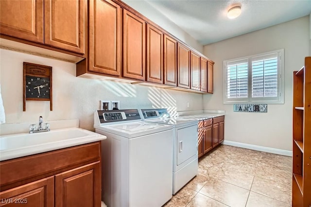 laundry area with cabinet space, baseboards, washer and clothes dryer, and a sink