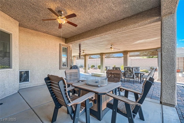 view of patio with fence, outdoor dining area, and a ceiling fan