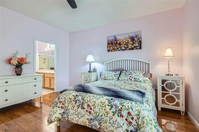 bedroom with wood-type flooring, baseboards, ceiling fan, and ensuite bath