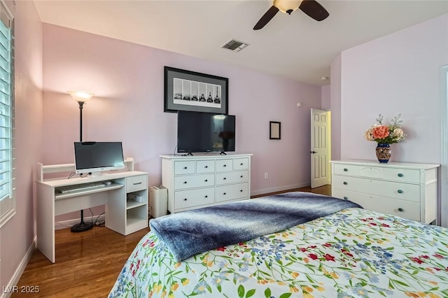 bedroom featuring a ceiling fan, wood finished floors, visible vents, and baseboards