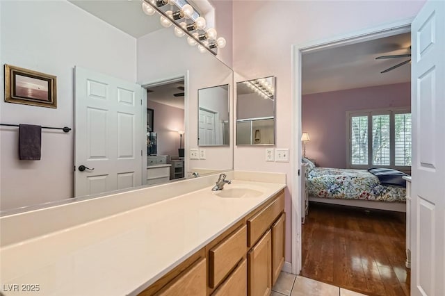 bathroom featuring ceiling fan, wood finished floors, ensuite bath, and vanity