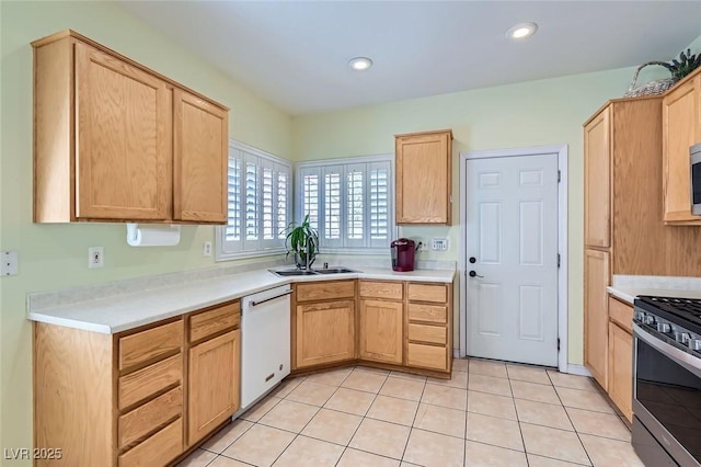 kitchen with light tile patterned flooring, recessed lighting, stainless steel appliances, a sink, and light countertops