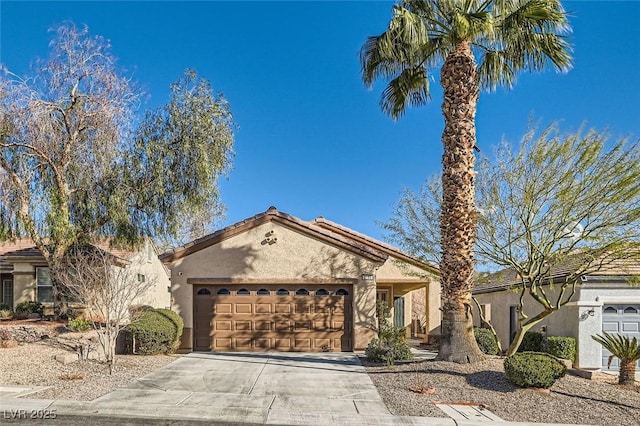 mediterranean / spanish house featuring an attached garage, driveway, and stucco siding