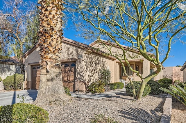 view of front of property with a garage, driveway, and stucco siding