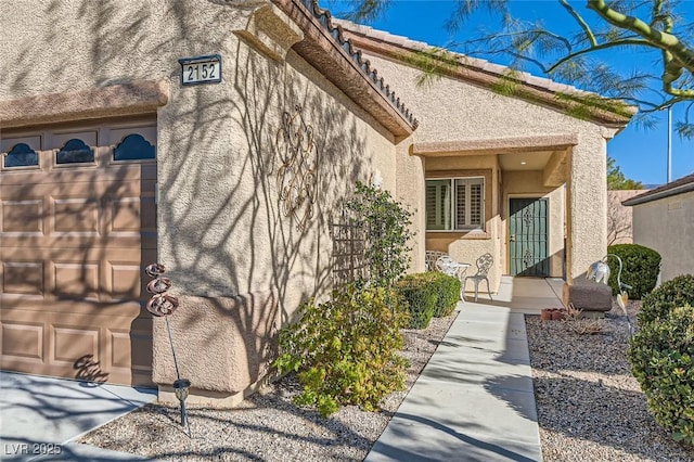 doorway to property featuring a tile roof and stucco siding