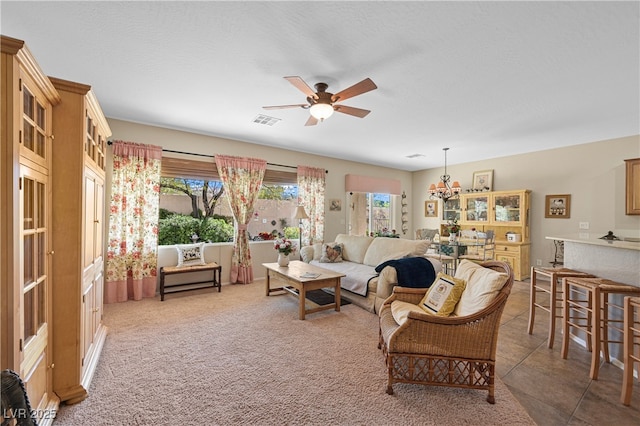 living area featuring visible vents, light colored carpet, and ceiling fan with notable chandelier