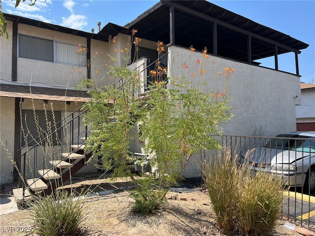 view of property exterior with stairway and stucco siding