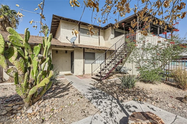 multi unit property featuring stairway and stucco siding