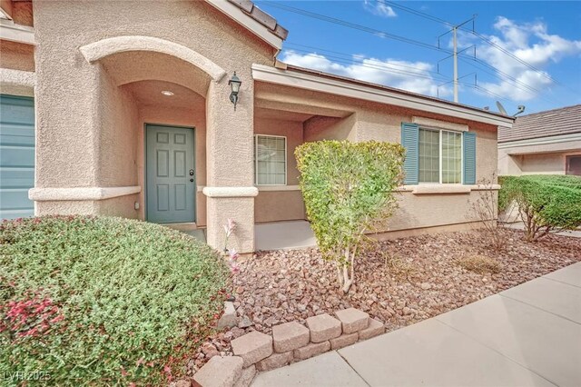 doorway to property featuring stucco siding