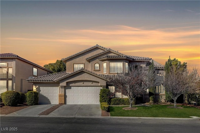 view of front of property featuring driveway, a lawn, an attached garage, and a tile roof