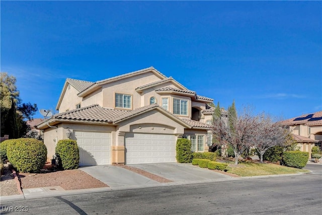 mediterranean / spanish-style home with driveway, a tile roof, and stucco siding