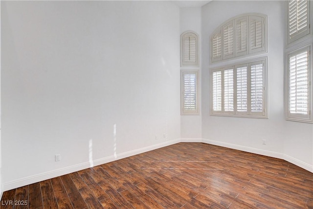 spare room with baseboards and hardwood / wood-style flooring