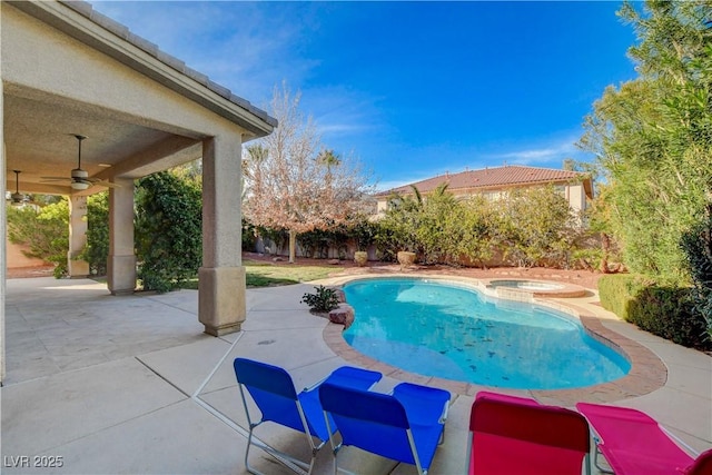 view of swimming pool featuring a patio, a pool with connected hot tub, fence, and a ceiling fan