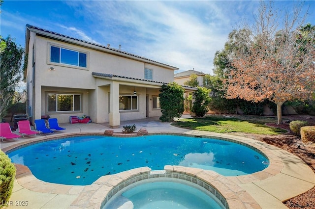 back of property with a patio, a tile roof, a pool with connected hot tub, and stucco siding