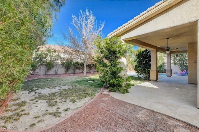 view of yard with a patio area, a fenced backyard, and a ceiling fan