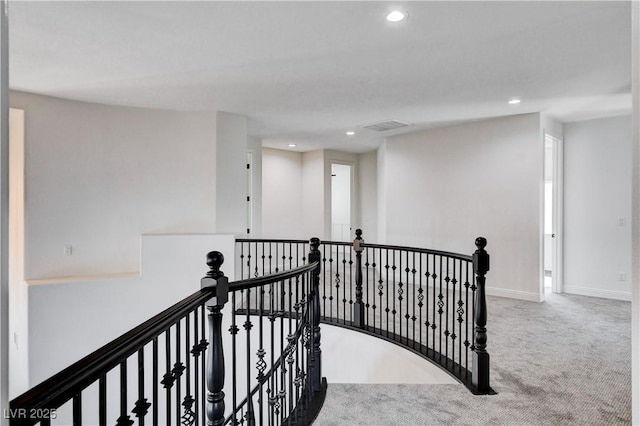 hall featuring visible vents, baseboards, carpet flooring, an upstairs landing, and recessed lighting