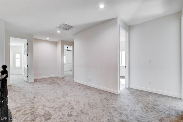 carpeted empty room featuring baseboards, visible vents, and recessed lighting