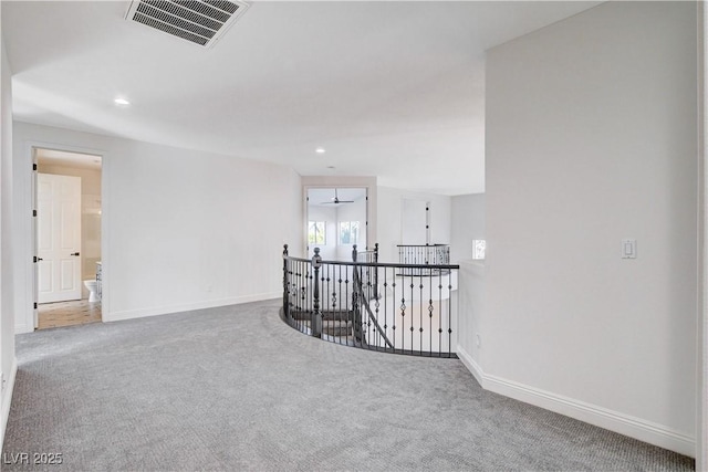 spare room with recessed lighting, carpet, visible vents, and baseboards