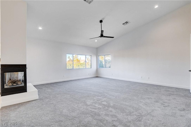 unfurnished living room with carpet floors, a multi sided fireplace, a ceiling fan, and baseboards