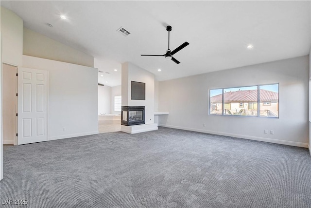 unfurnished living room with carpet, visible vents, a ceiling fan, and a multi sided fireplace