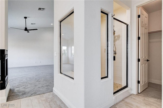 hallway with carpet, visible vents, and baseboards