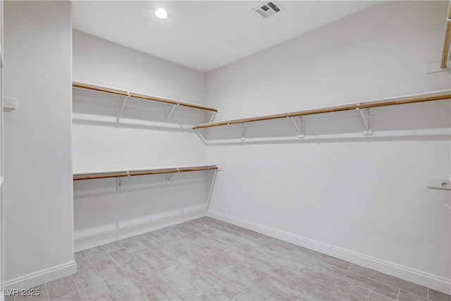 walk in closet with visible vents and wood finished floors