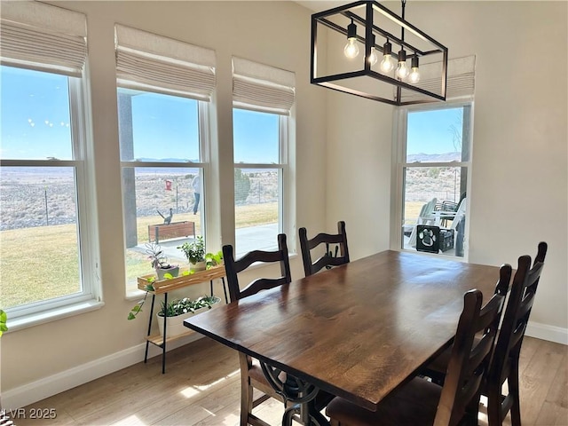 dining space featuring plenty of natural light, light wood-style flooring, and baseboards