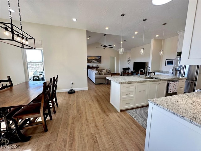 5208 Blue Desert Trl, Caliente, NV 89008 - kitchen with a sink, light wood-style flooring, open floor plan, white cabinets, and vaulted ceiling