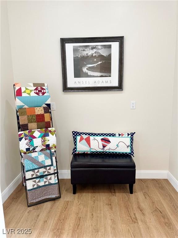 living area with baseboards and wood finished floors