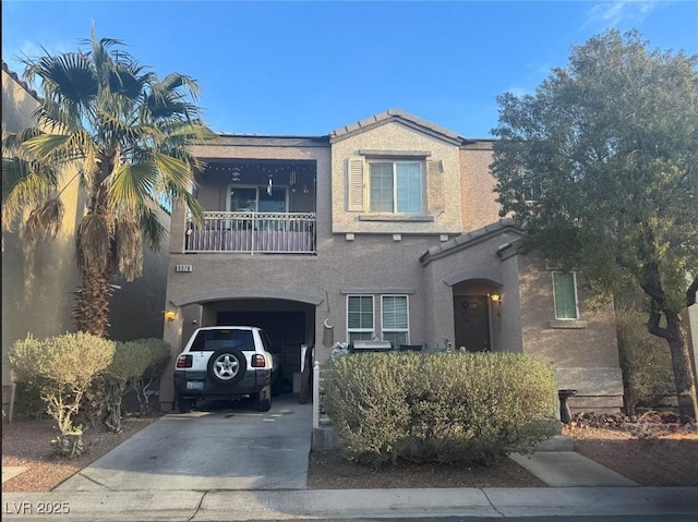 view of front of property with driveway, a balcony, an attached garage, and stucco siding