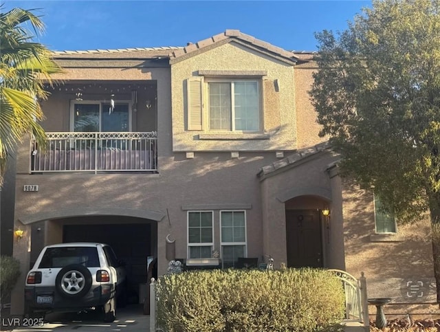 view of front of house featuring concrete driveway, a tiled roof, and stucco siding