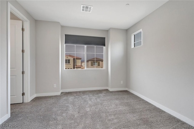 carpeted empty room with visible vents and baseboards